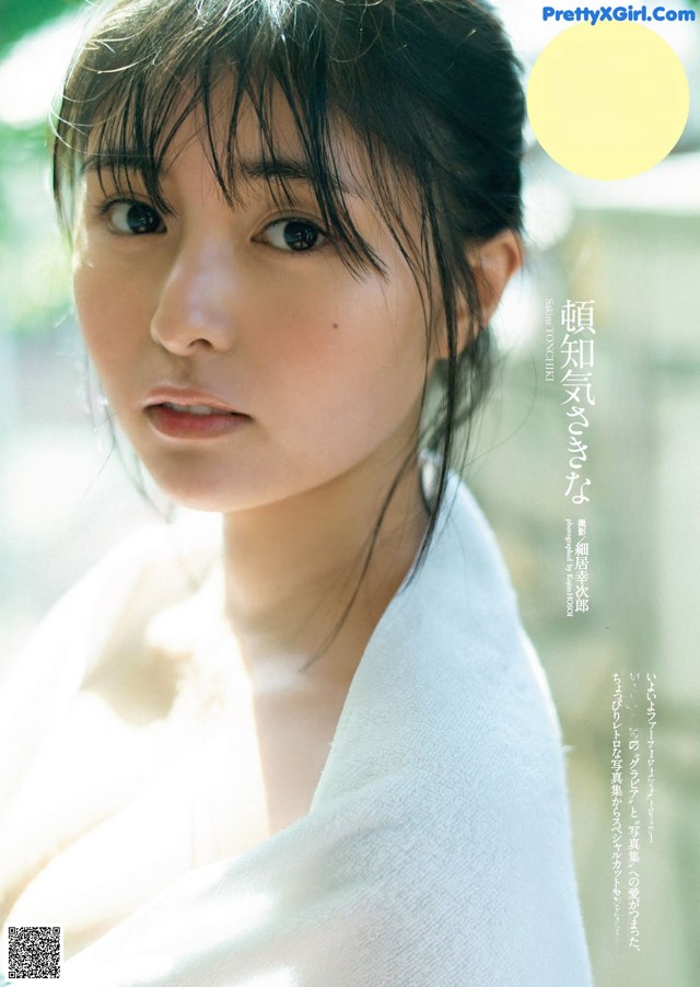 A woman in a white robe is posing for a magazine.