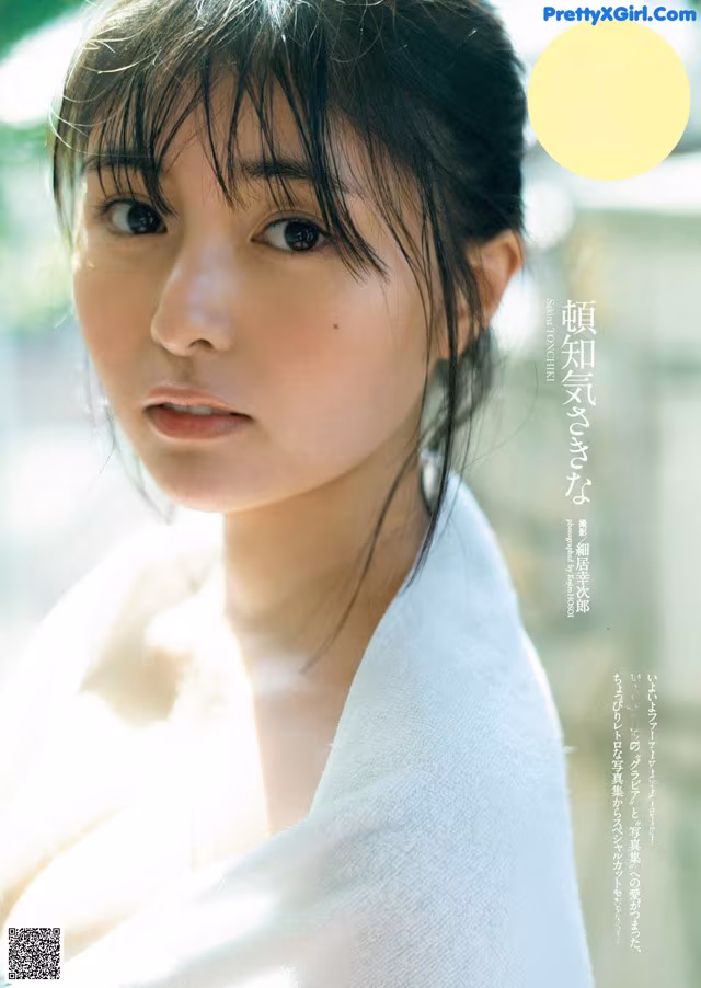 A woman in a white robe is posing for a magazine.