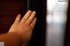 A person's hand on a wooden door. 