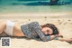 A woman laying on the beach in a bikini.