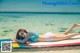 A woman laying on a surfboard in the ocean.