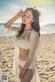 A woman in a white bikini standing on a beach.