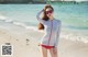 A woman in a bathing suit standing on a beach.