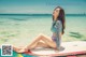 A woman sitting on a surfboard in the ocean.