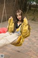 A woman sitting on a swing in a park.