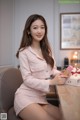 A woman sitting at a table holding a cupcake.