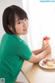 A woman sitting at a table with a plate of food.