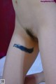 A woman with a tattoo of a feather on her thigh.