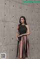 A woman standing in front of a concrete wall.