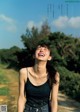 A woman laughing in the middle of a dirt road.