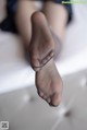 A close up of a person's feet in black stockings.