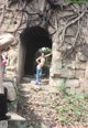 A naked woman standing in the middle of a stone tunnel.