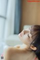 A woman laying on a bed with her eyes closed.