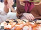 A woman sitting on a couch holding a tray of sushi.