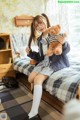 A girl sitting on a bed holding a teddy bear.