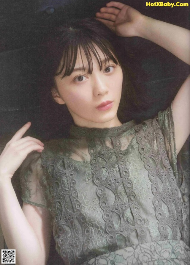 A woman in a green dress posing for a picture.